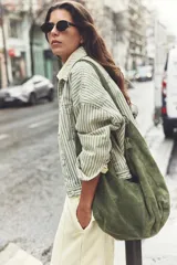 Bolso tote de ante suave, de cuerpo blando estilo hobo, con asa larga para el hombro y cierre superior con cremallera.