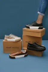 Zapatillas bajas color dorado con diseño trenzado, cordones y suela de goma.