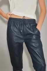 Babucha de cuero ovino color azul marino, con bolsillos frontales y cintura elastizada con tira de ajuste del mismo cuero y terminales metálicas.