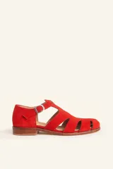 Sandalias estilo romanas planas, confeccionadas en gamuza roja, con múltiples tiras cruzadas, puntera redondeada y cierre lateral con hebilla metálica.