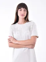 Vestido midi color crema, de corte recto y mangas cortas, con detalle de calado en forma de estrellas en el pecho.