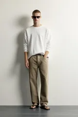 Camiseta relaxed fit de manga larga color blanco, confeccionada en tejido de modal y algodón fluido, con cuello redondo y puños de rib.
