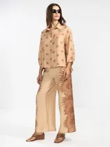 Pantalón palazzo negro con estampado de sirenas en color beige.