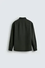 Camisa de corte regular fit confeccionada en tejido de algodón con textura de cuadrillé. Presenta cuello solapa, manga larga con puños abotonados y cierre frontal mediante botonadura.