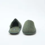Zapatillas de estar por casa tipo mule, confeccionadas en tejido de fieltro color verde kaki, con suela plana y diseño cerrado en la parte delantera.