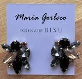 Par de caravanas con forma de flor, con cristales facetados en tonos lila, blanco y dorado.