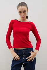 Remera de algodón color rojo con escote bote y detalle de borde en color negro. De manga larga y corte ajustado al cuerpo.