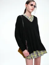 Sweater de punto color gris, con escote en V profundo, hombros caídos y diseño holgado de corte relajado.