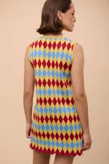 Vestido corto sin mangas con estampado de rombos en azul, rojo y amarillo. Tiene escote con forma de gota y terminación en picos.