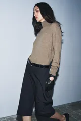 Bermuda larga de tiro medio, color azul marino con finas rayas diplomáticas blancas. Presenta cintura con trabillas, bolsillos laterales ocultos en costura y cierre frontal con cremallera, botón y ganchos metálicos.