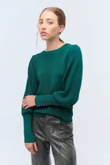 Sweater color crema de tejido de punto con lurex, mangas abullonadas y puños con botones metálicos.