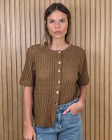 Cardigan de punto calado color tostado, de manga corta, con cuello redondo y cierre frontal de botones.