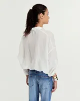 Camisa blanca de ramio con fit oversize y hombro caído. Manga larga con sistema de ajuste regulable con ojal y botón para acortar. Ruedo con sistema de ajuste regulable para fruncir.