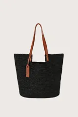 Bolso tote negro de tejido de rafia con asas largas y detalle de etiqueta colgante de cuero sintético en color tostado.
