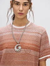 Vestido corto de tejido de punto con efecto degradado, cuello redondo y mangas cortas con puños a rayas en contraste. Presenta un diseño holgado y calado.