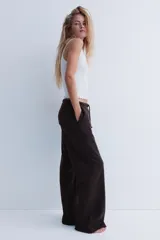 Jogger de felpa color marrón oscuro, con cintura elástica y cordón ajustable. Diseño de corte holgado con bolsillos laterales discretos y piernas amplias.