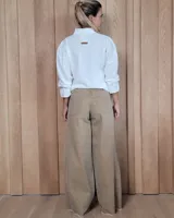 Pantalón de jean azul de tiro medio, con corte wide leg y ruedo deshilachado.