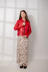 Chaqueta de cuero ovino en color rojo, con corte recto, cuello clásico, hombros definidos y cierre frontal con cremallera metálica. Presenta bolsillos laterales con cierre y puños con cremallera.