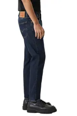 Pantalón de jean corte slim taper, con ajuste entallado en el muslo y pierna que se estrecha hacia el tobillo. Presenta un lavado azul oscuro clásico con costuras en contraste y cierre frontal con botón y cremallera.