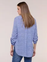 Camisa azul con estampa geométrica, de corte clásico y calce relajado, con cuello camisero tradicional, cierre frontal de botones y mangas largas con presillas para arremangar.