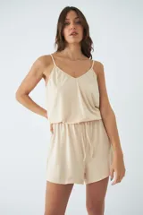 Mono corto de tirantes finos con escote en V, cintura elástica con cordón ajustable y espalda descubierta.