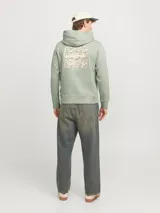 Buzo con capucha verde claro, de corte clásico, con puños y ruedo acanalados. Estampa trasera con diseño abstracto en tonos beige y texto con el logo de la marca.