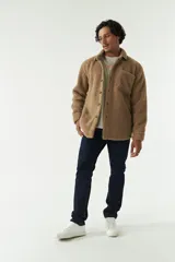 Sobrecamisa de sherpa color crema con cuello camisero, cierre frontal con botones a presión y bolsillo de parche en el pecho. El modelo usa talle M.