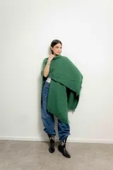 Ruana tejida de color verde esmeralda con flecos en el borde.