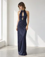 Vestido largo de satén color azul marino, con cuello halter, aberturas frontales y diseño fluido que estiliza la figura.