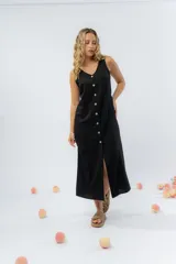 Vestido largo de lino con escote en V, diseño recto y fluido, con cierre frontal abotonado mediante botones de madera.