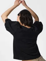 Top negro de algodón orgánico, de corte relajado, con cuello redondo y mangas cortas abullonadas.