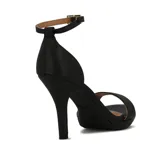 Sandalia de tacón alto negra, con plataforma delantera y una tira ancha sobre los dedos. Posee una tira fina alrededor del tobillo con hebilla metálica dorada para ajuste.