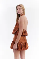 Top metalizado color cobre, con cuello halter y diseño balloon con caída fluida.
