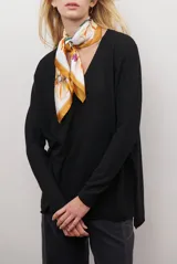 Sweater de tejido de punto color beige, con escote en V y mangas largas. Presenta un diseño básico y versátil de corte recto.