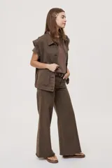 Pantalón jean de tiro medio, color negro, de corte amplio y silueta extra wide leg. Presenta diseño clásico de cinco bolsillos, cierre frontal con botón y cremallera, y detalle de tachas metálicas aplicadas a lo largo de los laterales.