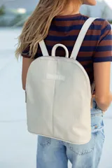 Mochila de cuero color natural con textura, cierre superior con doble cremallera, asa de mano y correas ajustables para los hombros.