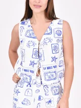 Chaleco blanco con estampado de motivos marinos en azul. Tiene escote en V y cierre frontal con lazos.