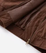 Campera bomber de pana color marrón, con cuello polo, cierre frontal con cremallera y puños y bajo elásticos.