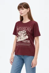 Remera de manga corta y cuello redondo, de corte holgado, color bordó con estampa frontal temática de naturaleza y hongos.
