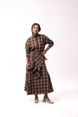 Camisa de corte recto y mangas largas con estampado de cuadros tartán en tonos marrones y beige. Presenta cuello camisero y cierre frontal con botones.