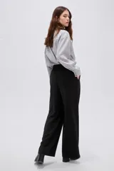 Pantalón negro de tiro alto, confeccionado en viscosa, de corte holgado y pernera ancha, con bolsillos laterales.