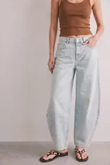 Jean baggy de tiro bajo con diseño barrel de perneras curvadas, confeccionado en denim de algodón con lavado claro.