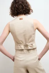 Chaleco sastre color amarillo mostaza, confeccionado en lino con forro de algodón y cierre frontal con botones.