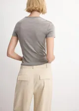 Remera gris de manga corta, cuello redondo y corte ajustado al cuerpo.