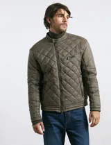 Campera capitoneada de color azul oscuro, con cierre frontal de metal y botones a presión. Presenta bolsillos laterales y en el pecho con cierres metálicos.