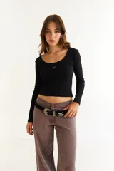 Top de manga larga color marrón, confeccionado en tejido de punto acanalado. Presenta un escote cuadrado y un detalle bordado con las iniciales BG en el centro del pecho.