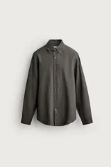 Camisa celeste de lino de corte regular fit, con cuello abotonado, manga larga y cierre frontal de botonadura.