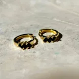Par de aros tipo argolla dorados con diseño de tres rectángulos negros en el centro.