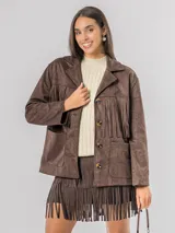 Chaqueta de estilo boho confeccionada en ecocuero agamuzado, con diseño de flecos en el frente, cierre frontal con botones y bolsillos laterales. Presenta un corte holgado y forro interior.