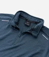 Remera deportiva de manga larga con cuello alto y cierre frontal parcial. Presenta una textura acanalada en toda la prenda y detalles reflectivos en los hombros.